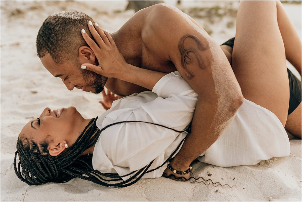 black couple on beach covered in sand