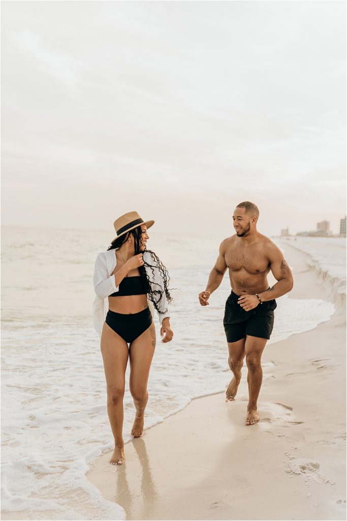 couple running in ocean in swimwear 