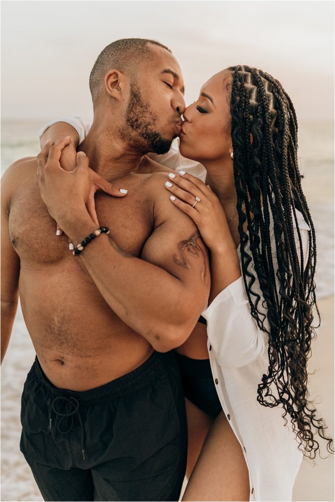 couple kissing on beach engagement session