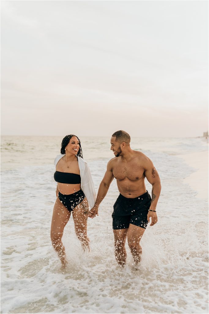 couple running and splashing on beach