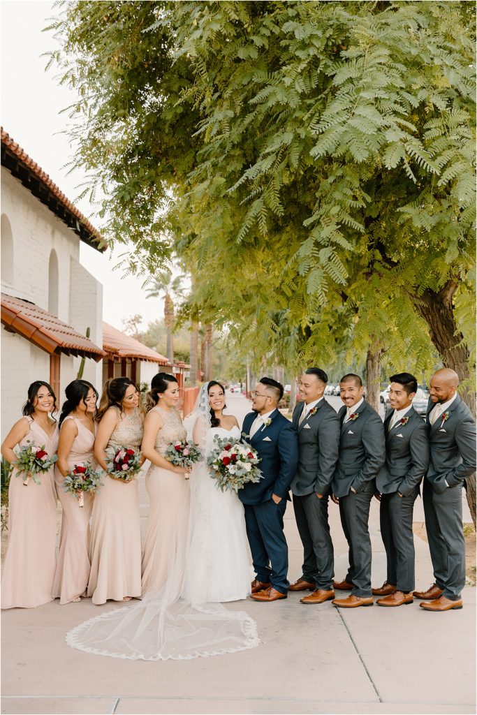 wedding party smiling at couple during portraits at backyard palm springs wedding venue