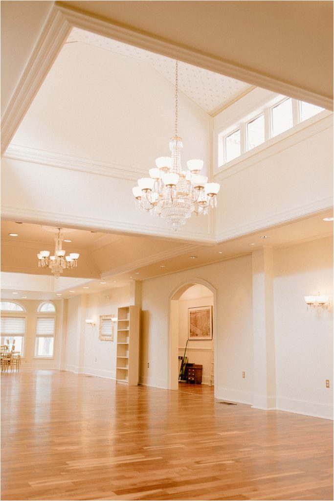 Gingerbread House Wedding Venue Empty Ballroom with wood floors and chandeliers